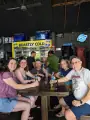 A group of guests seated together with drinks at a bar stop.