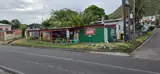 A wide street view of a green bar and neighbouring buildings along a St. Kitts road.