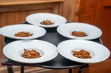 Five white bowls of rice dishes arranged for guests on the Carambola food tour.